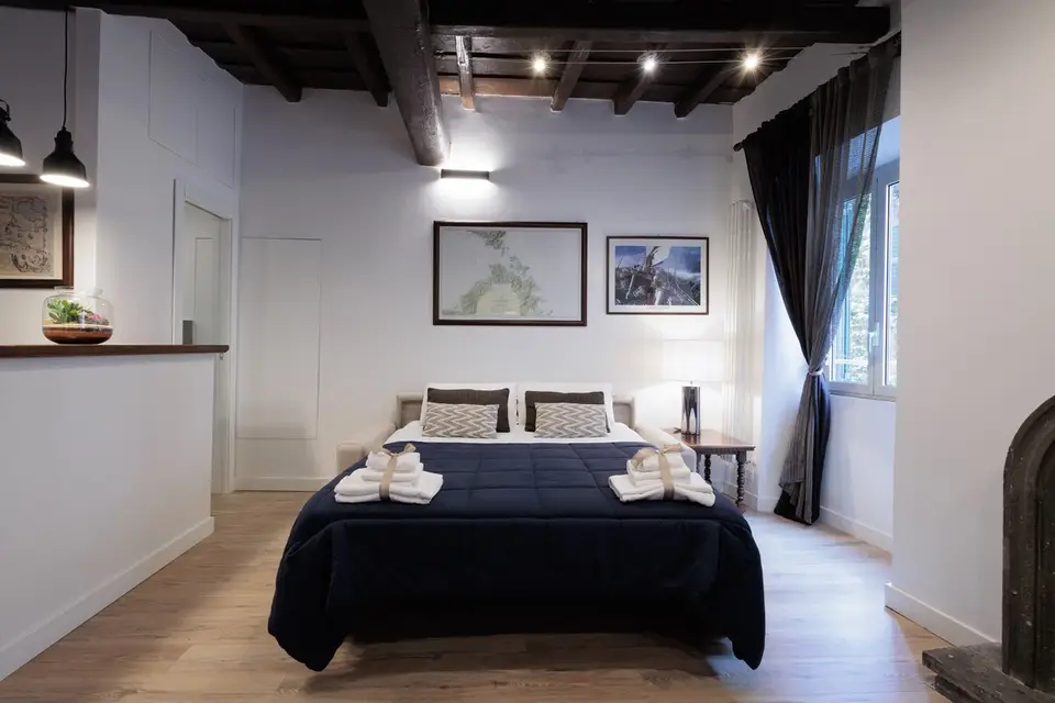 The bedroom with double bed and, through the arch, the bathroom with its backlit round mirror.