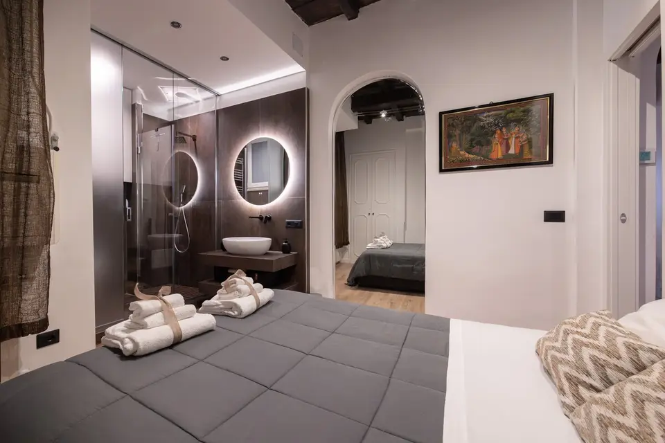 The bathroom in dark stoneware, countertop basin and circular backlit mirror.
