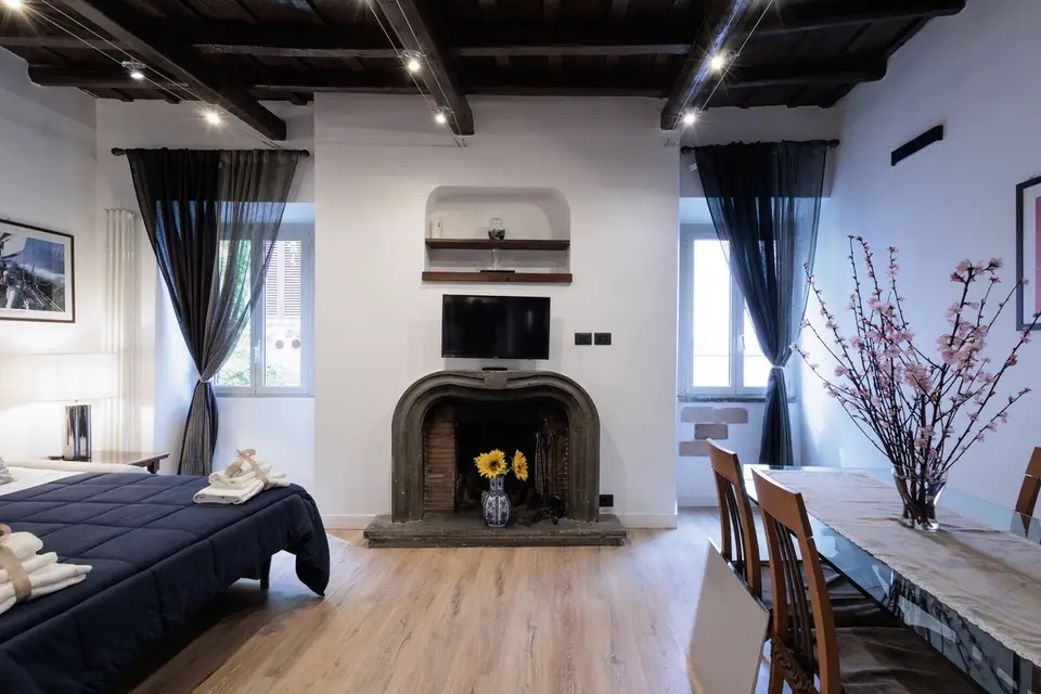 Bedroom with double bed, stone fireplace and windows onto the lane.